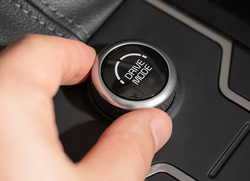 Hand adjusting car drive mode dial